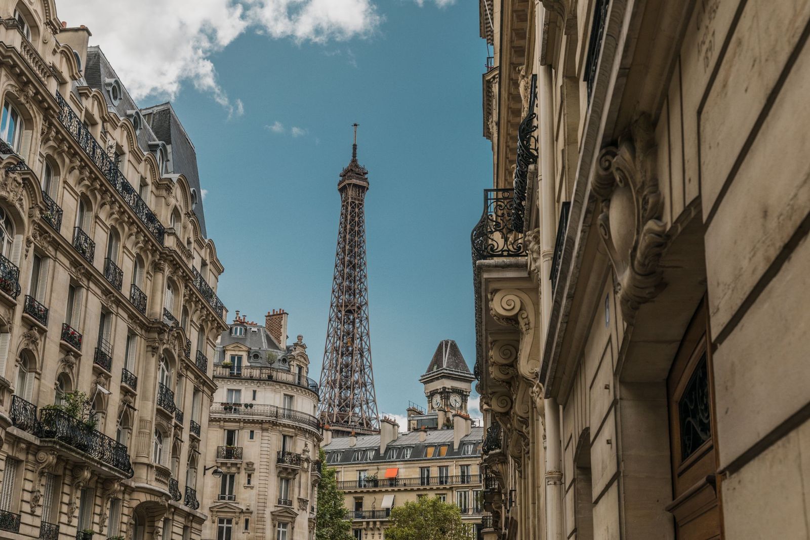 A Paris street with the Eiffel Tower between the buildings