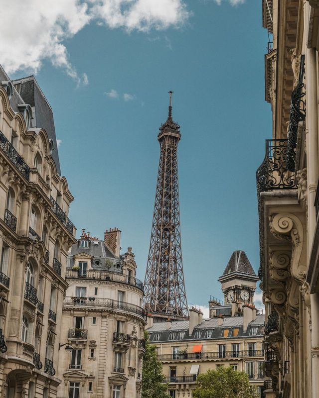 A Paris street with the Eiffel Tower between the buildings