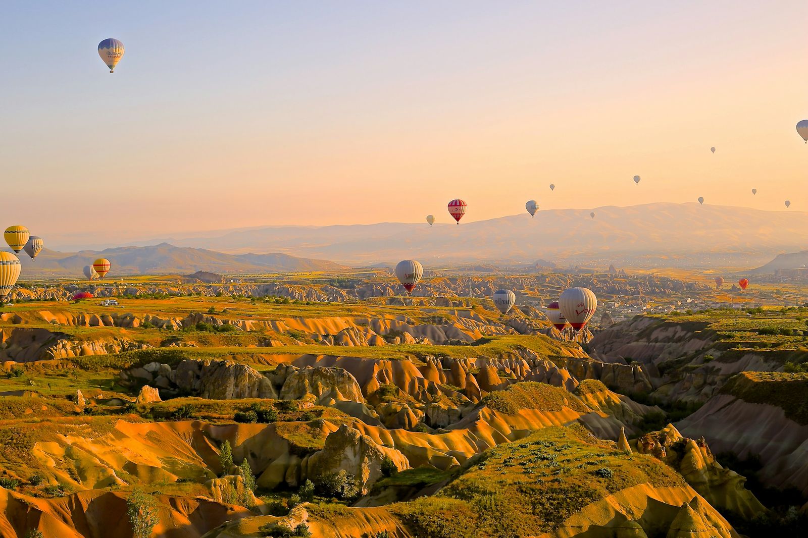 Hot air balloons over a valley at sunrise