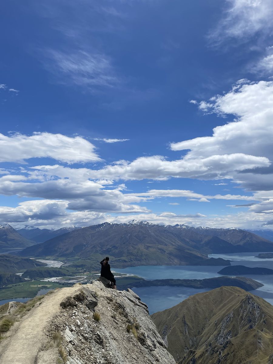 Julia sitting on a rock high above Lake Wānaka